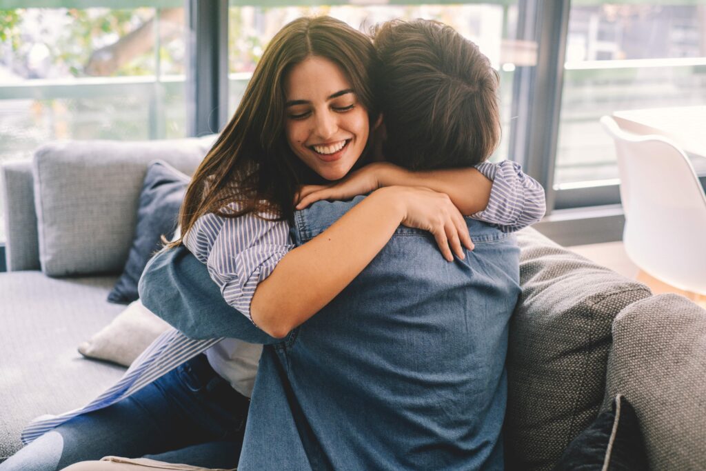 Beautiful young couple hugging in their new apartment. scaled
